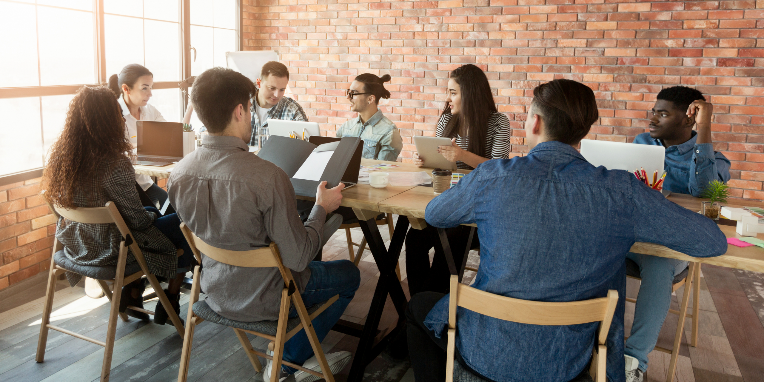 Photo shows a group of people sat around a table in a training session.